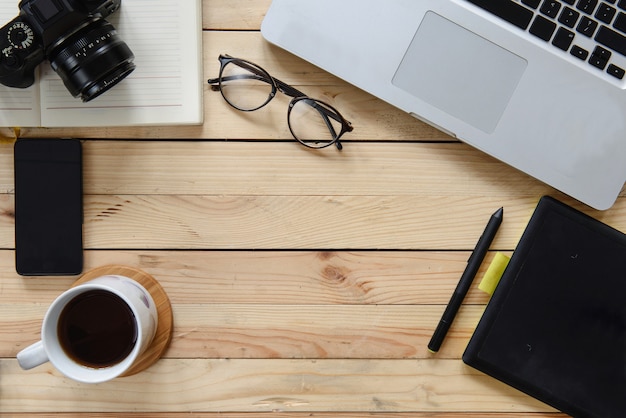 Working table of photographer or artist overhead view, wooden surface with free space