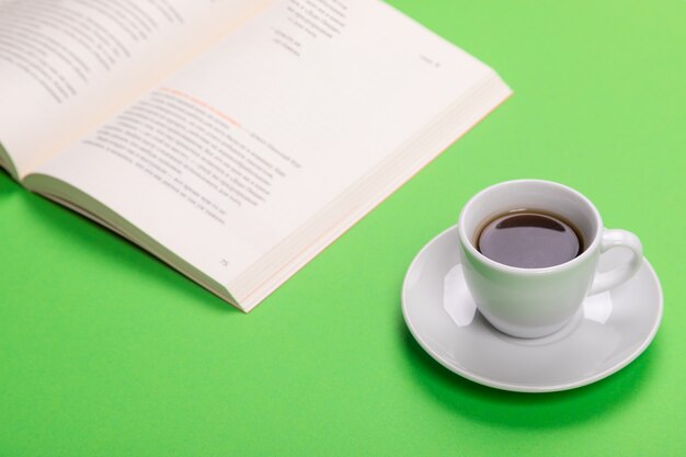 Working table with cup of coffee and book isolated on green tshirt