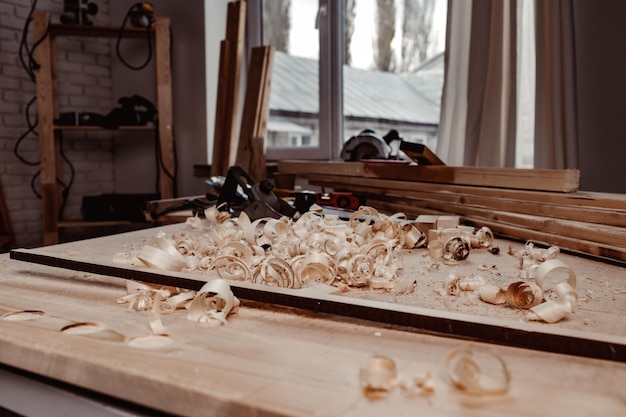 Working table with wood shavings in carpentry workshop