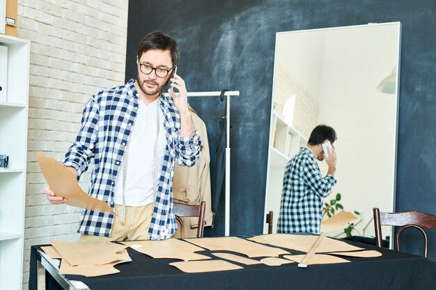 Working tailor in atelier having call