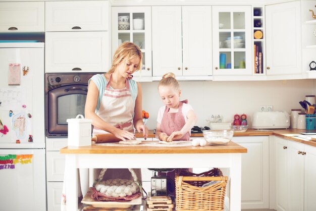 Foto lavorare insieme per cuocere qualcosa di delizioso bambina carina che cuoce in cucina con sua madre