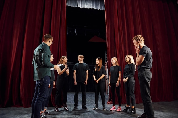 Working together Group of actors in dark colored clothes on rehearsal in the theater