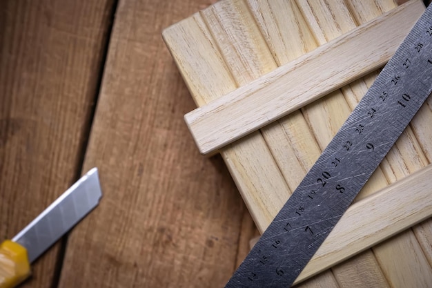 Working tools ruler and stationery knife on a working wooden table