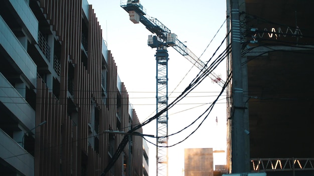 Working tower crane hanging wires on the foreground