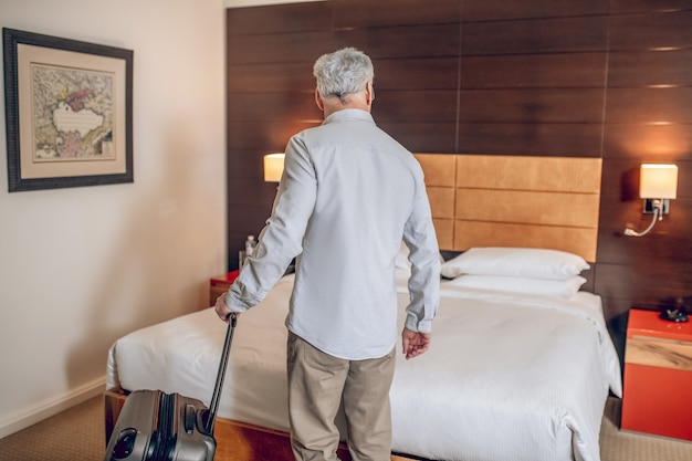 Photo working trip. gray-haired good-looking man arrived to the hotel