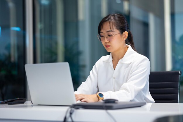 Photo working woman business woman busy working on laptop computer at moder office workspace attractive beautiful asian business woman working in home office