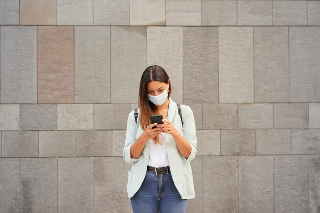写真 スマートフォンを使って市内で働く女性。彼女はコロナウイルスのパンデミックを隠蔽している。