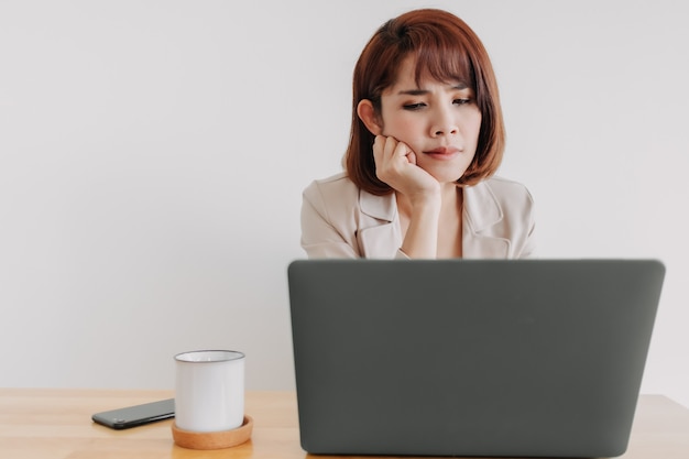 Working woman is using laptop on the office desk with white background