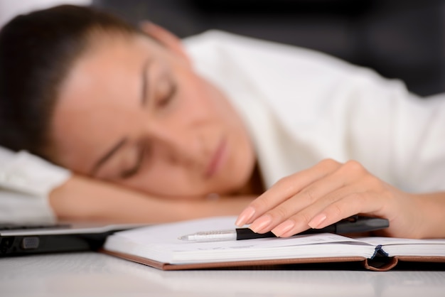 Working woman sleeping on her laptop at the workplace