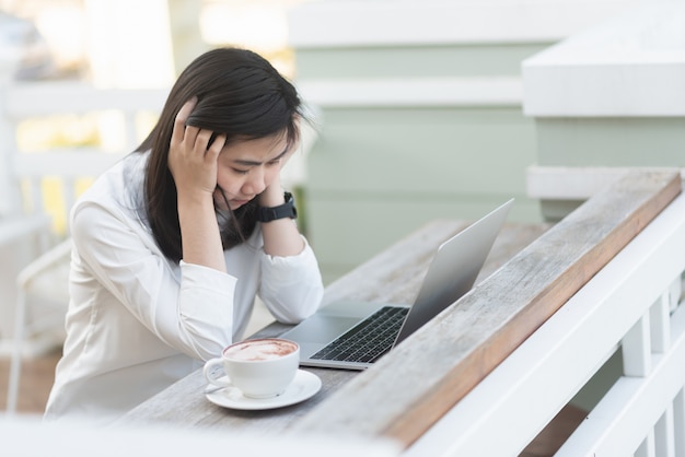 カフェでラップトップを使用して働く女性