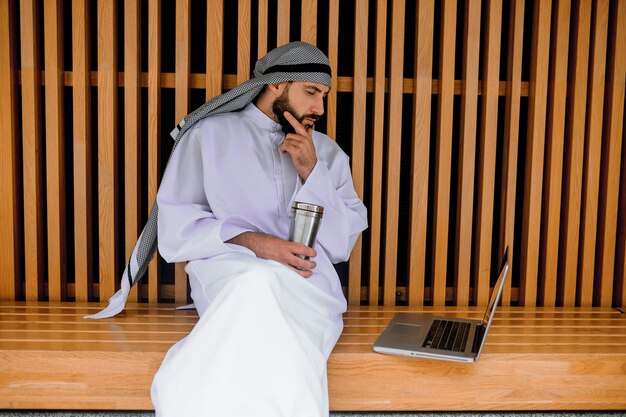 Working. Young arabian businessman working on a laptop and looking involved