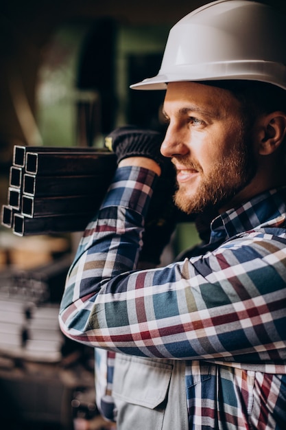 Workman wearing hard hat working with metal constructions at factory