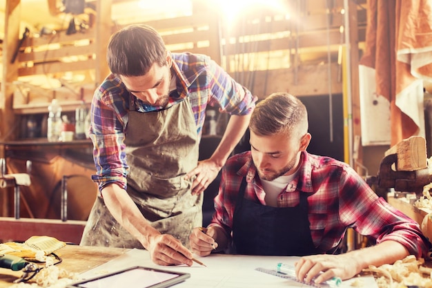 Photo workmen with tablet pc and blueprint at workshop