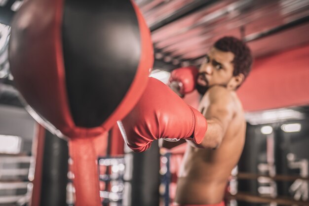 Workout. African american kickboxer having a workout in a gym and looking concentrated