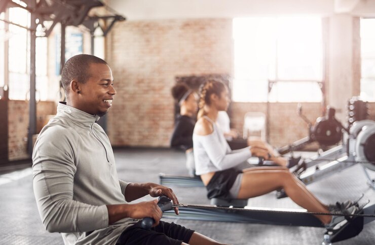 Foto workout gym en man op roeimachine voor gezondheid, wellness en lichaamsfitness met klasse uithoudingsvermogen oefening en mannelijke atleet op ergometer apparatuur voor cardio of krachttraining in het sportcentrum