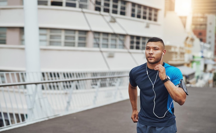 Foto workout hardlopen en man op de brug in de stad met gezondheid wellness of koptelefoon voor streaming urban fitness lichaamsverzorging en hardloper luisteren naar muziek podcast of training op straat voor ochtend oefening