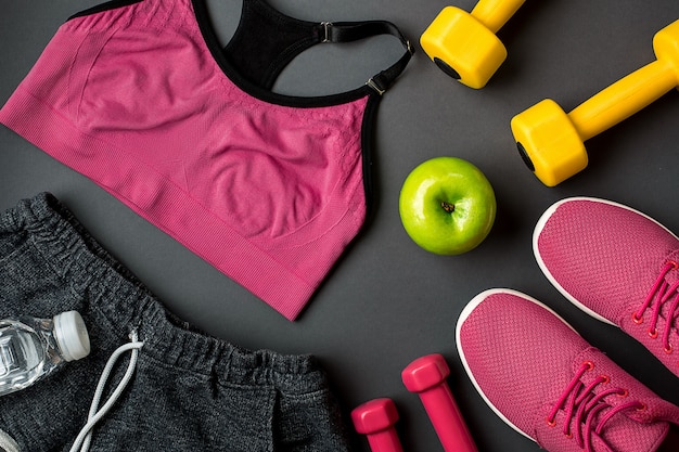 Workout plan with fitness food and equipment on gray background top view