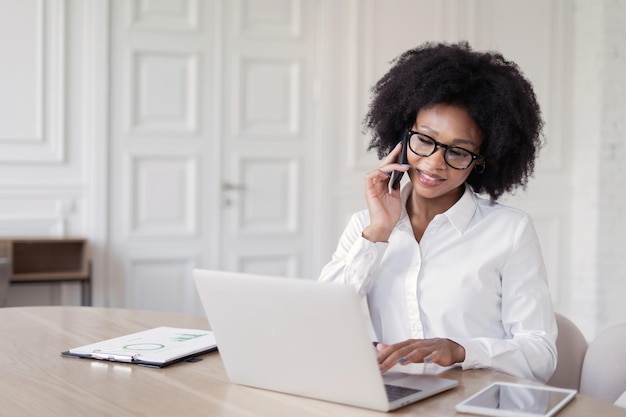 A workplace for an apartment designer a young freelance woman\
is working in an office on a laptop