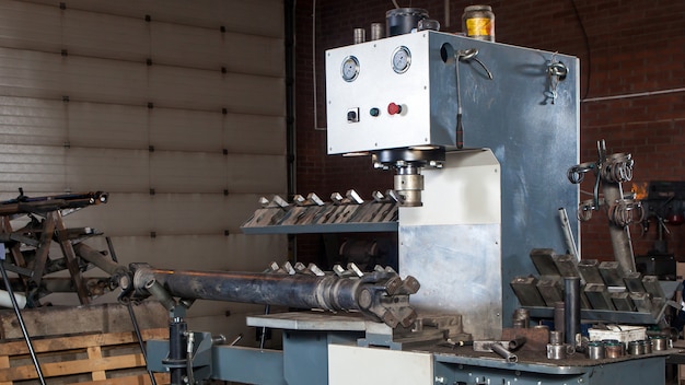 Workplace of a car mechanic for repairing cars and trucks: automatic installation for the repair of cardan shafts, mettalic hammers, clamps and spare parts in the workshop