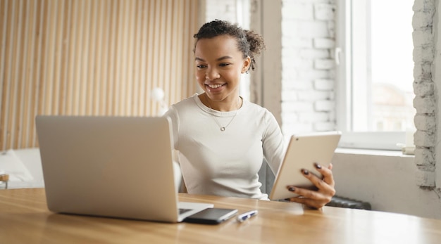 Workplace in a coworking space a woman uses a laptop to work in\
an office online with colleagues