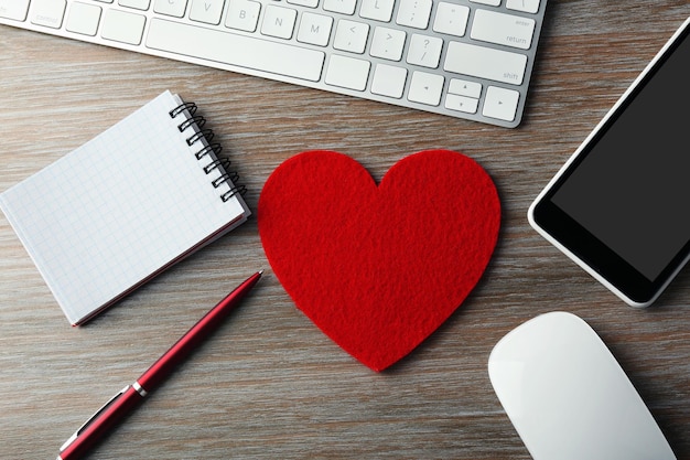 Workplace decorated with Valentine's heart top view