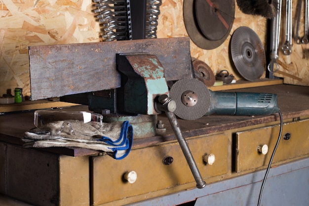 workplace of the home master locksmith protective glasses working gloves and a cutting machine