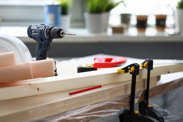 At workplace joiner is hand drill, vise holds bar