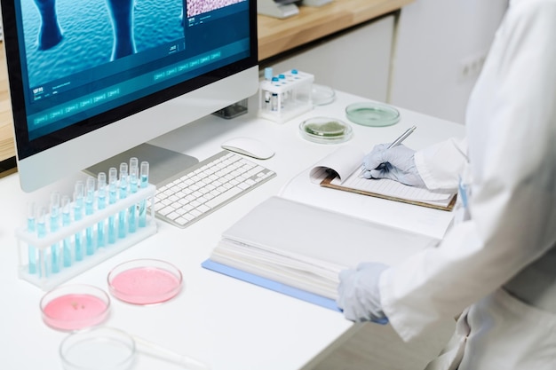 Photo workplace of modern biotechnologist with flasks petri dishes and computer