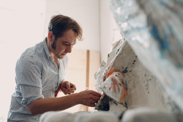 Workplace mosaics master making smalt glass mosaic panel Man mosaicist at work