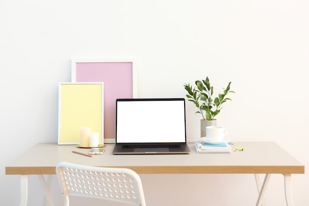 Workplace near the wall with a modern laptop