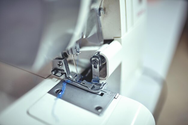 Workplace of tailor - sewing machine, rolls of of thread, fabric, scissors.