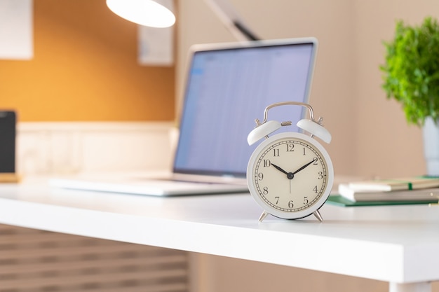 モダンなスタイルの目覚まし時計付きの職場。ビジネスコミュニケーションの概念。ホームオフィスの職場。