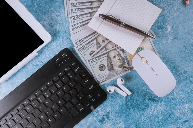 Foto posto di lavoro con computer e dollari in contanti.