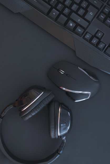 Photo workplace with a keyboard, mouse and headphones on a black background. copyspace