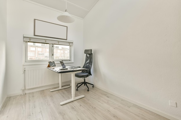 A workplace with a laptop on a table in a spacious bright room