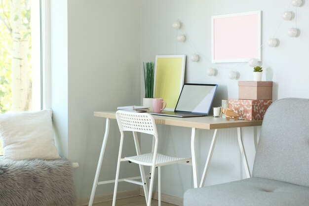 Photo workplace with modern laptop in the interior of the room