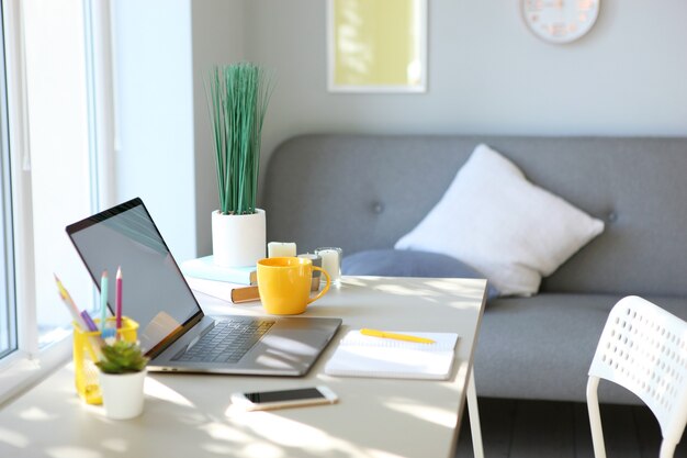 Photo workplace with modern laptop in the interior of the room