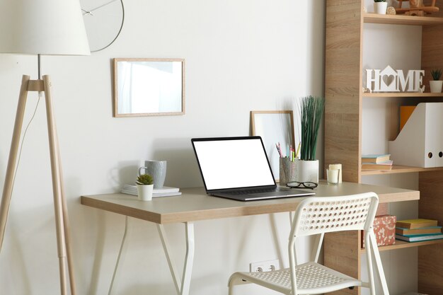 Photo workplace with modern laptop in the interior of the room
