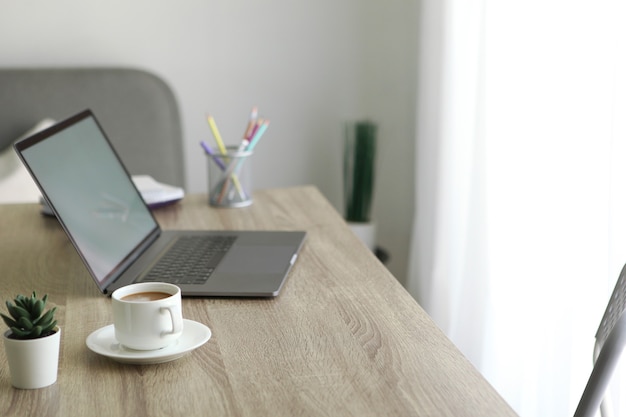 Workplace with modern laptop in the interior of the room