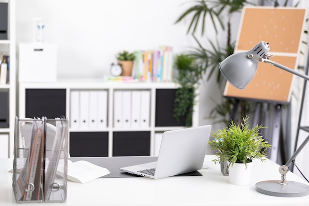 Photo workplace with notebook laptop comfortable work table in office 