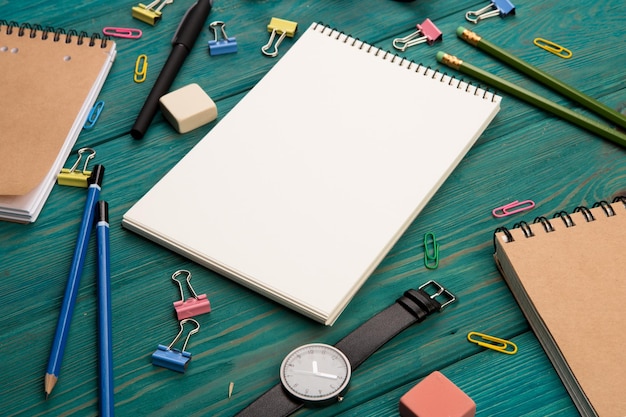 Workplace with notepad glasses watch and other office supply on a desk