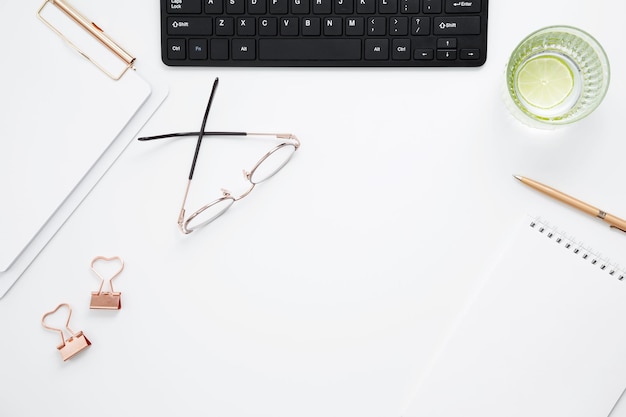 Foto posto di lavoro con notebook bianco cancelleria per tastiera nera scrivania da ufficio a disposizione piatta per simulare lo spazio per il testo