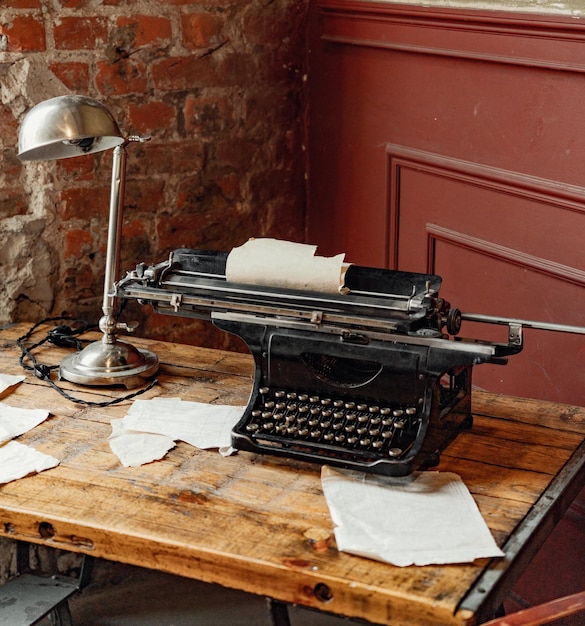 Foto il posto di lavoro di uno scrittore o giornalista una macchina da scrivere vintage si trova su un vecchio tavolo di legno