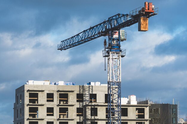 Worksite with crane new buildings or houses under construction with cloudy sky in the background