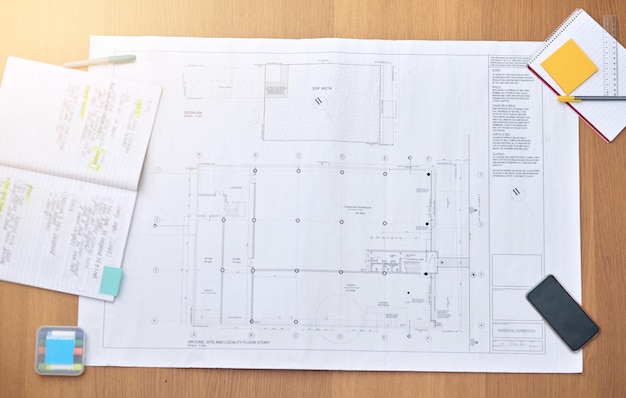 Photo the workspace of an architect high angle shot of blueprints on a desk