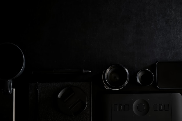 Workspace on black leather top table of a creative designer or photographer and copy space