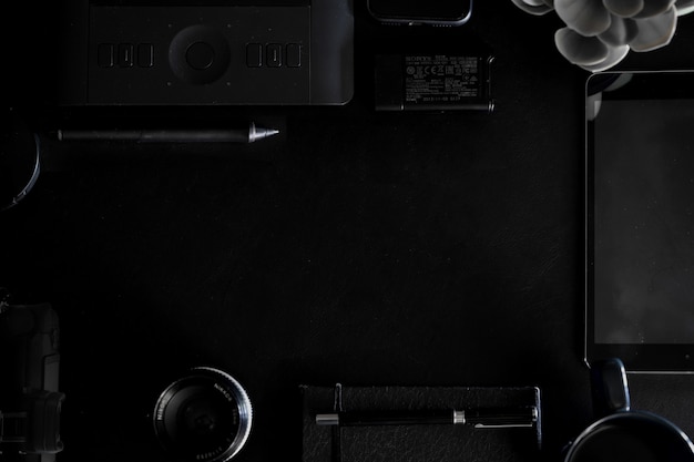 Workspace on black leather top table of a creative designer or photographer and copy space