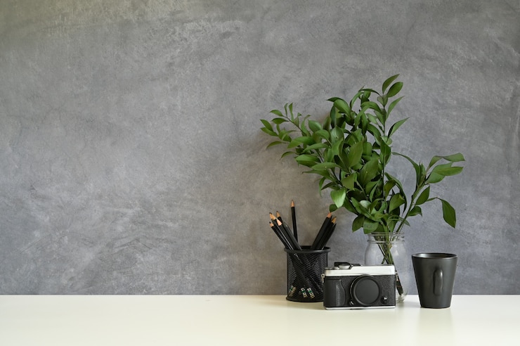 Photo workspace camera, coffee, pencil and plant decorate on white desk and loft wall.