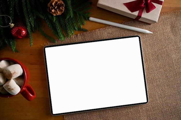 Workspace in Christmas holiday theme tablet mockup on a wooden table