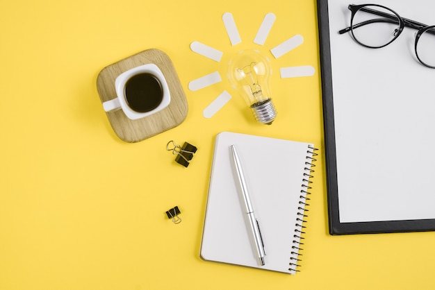 Photo workspace desk styled design office supplies with pen, notepad, eyeglasses, cup coffee and light bulb